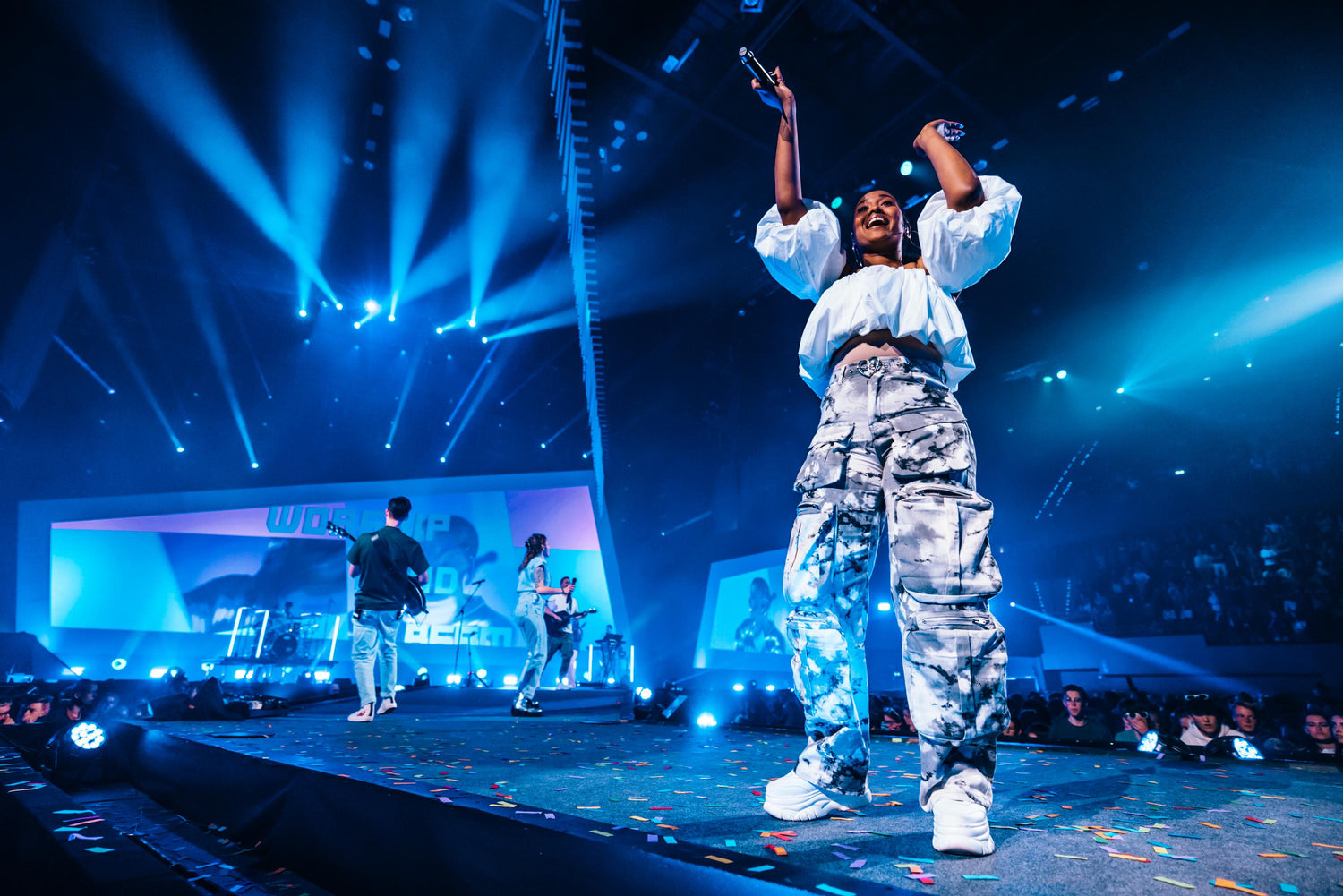 Ilaisa energizing the crowd on the EO Jongerendag arena stage under blue concert lights