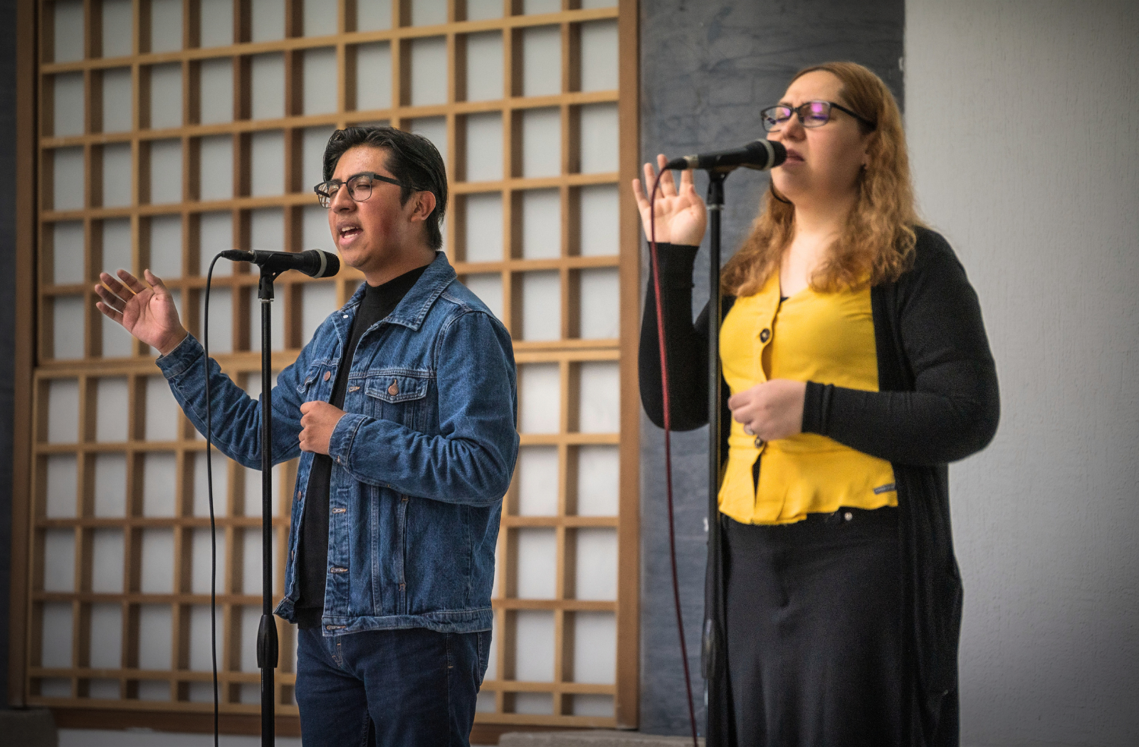 Two vocal students singing a duet into microphones during Ilaisa’s private singing lesson session