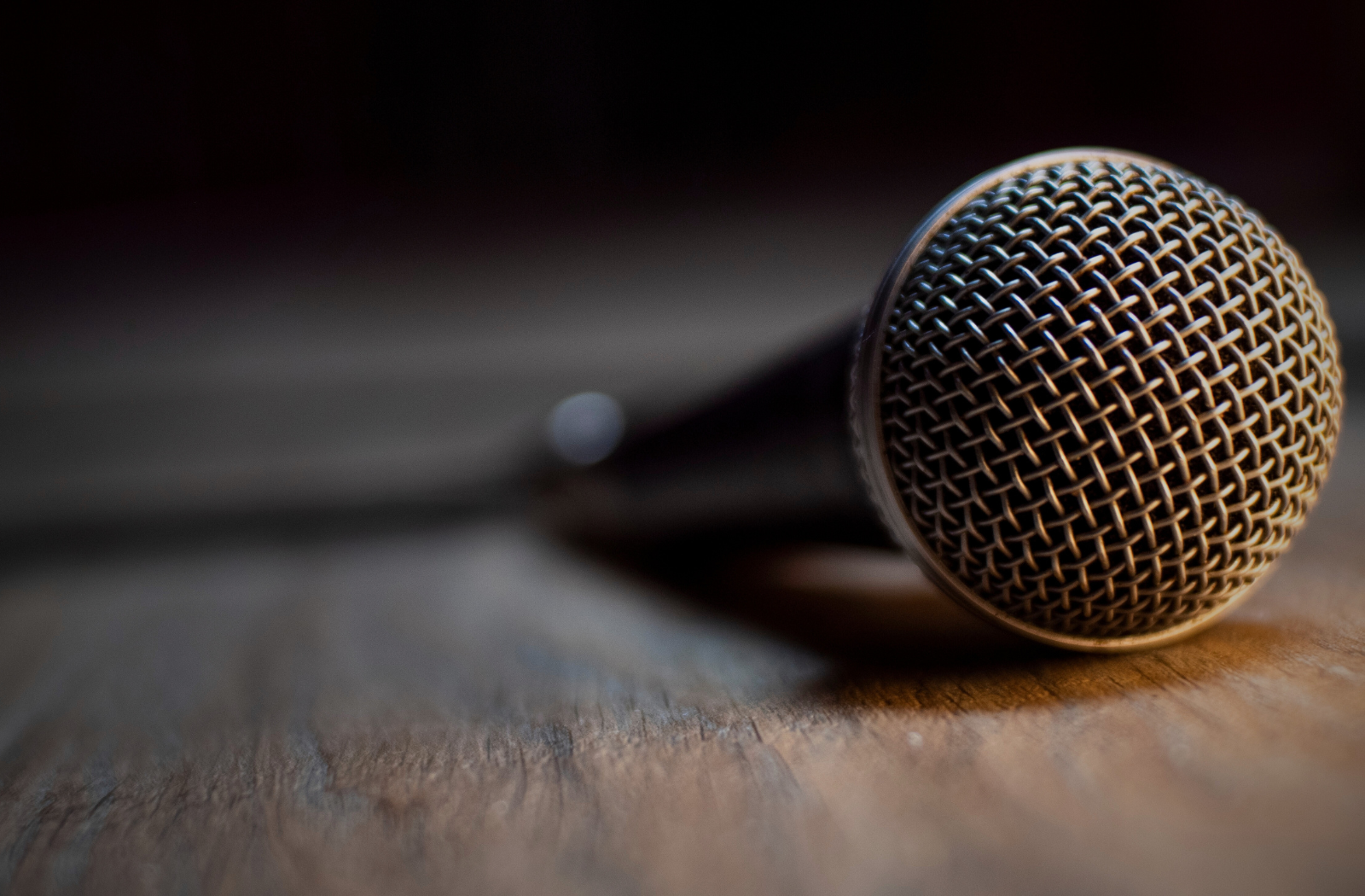 Close-up microphone on stage floor representing Ilaisa’s private singing lessons and vocal coaching