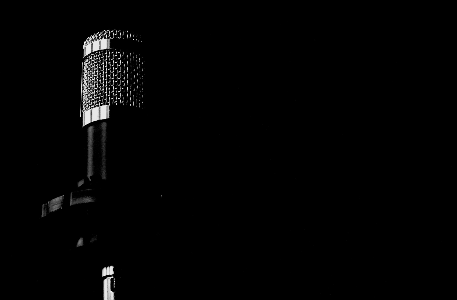 Studio microphone in dramatic lighting representing Ilaisa’s private vocal lessons and professional vocal coaching