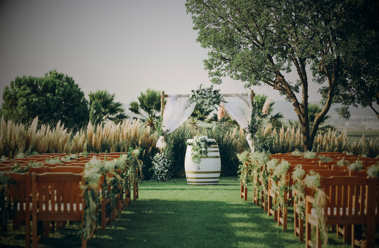 Outdoor garden wedding aisle with floral arch, perfect setting for live ceremony music by Ilaisa